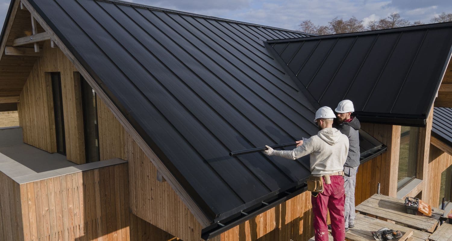 Roofers working together on a standing-seam roof